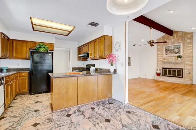 a kitchen with stainless steel appliances kitchen island granite countertop a refrigerator and a stove top oven