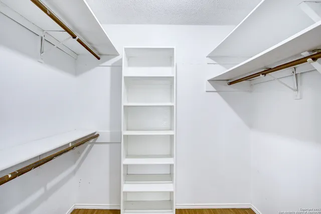 a view of walk in closet with empty racks