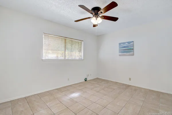 an empty room with a window and a fan