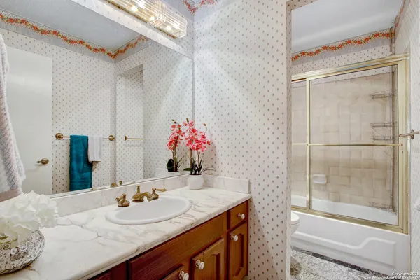 a bathroom with a granite countertop sink and a mirror