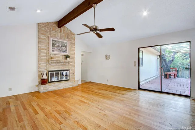 a view of a big room with wooden floor and windows