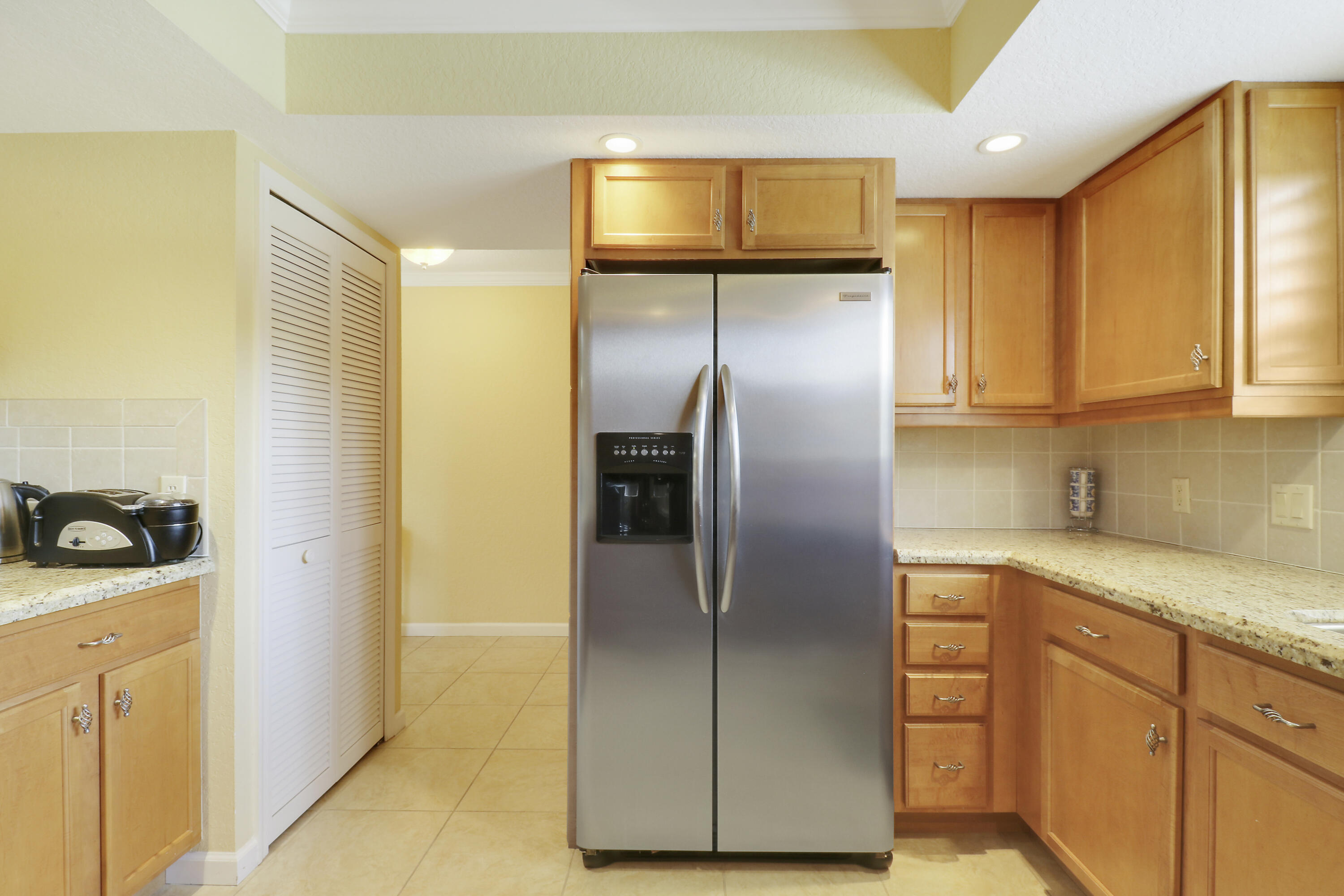 4161 U.S. Highway 1, Unit C2 Jupiter, FL 33477 - Photo 15 of 57 a kitchen with a refrigerator and cabinets