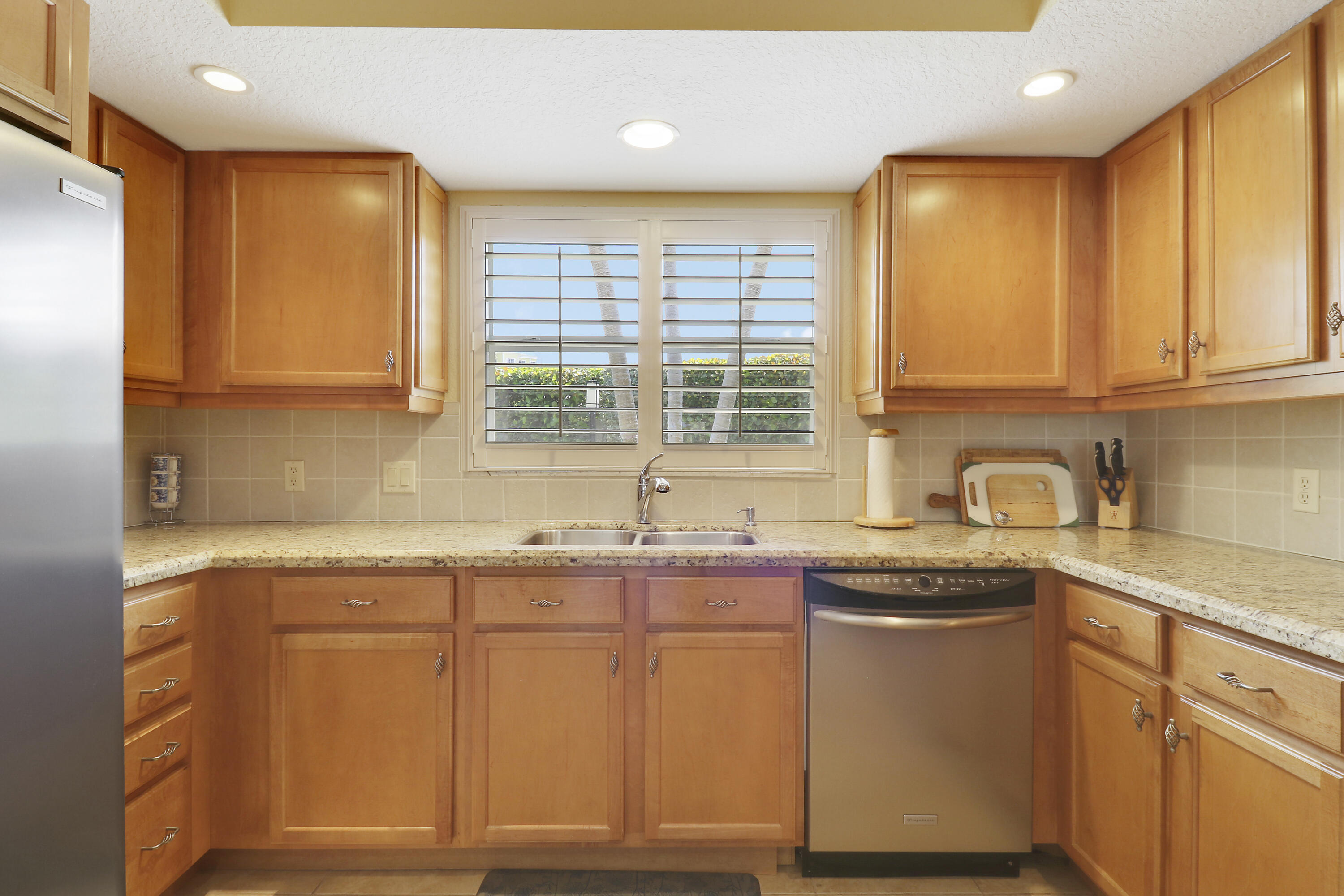 4161 U.S. Highway 1, Unit C2 Jupiter, FL 33477 - Photo 16 of 57 a kitchen with stainless steel appliances granite countertop a sink stove and cabinets