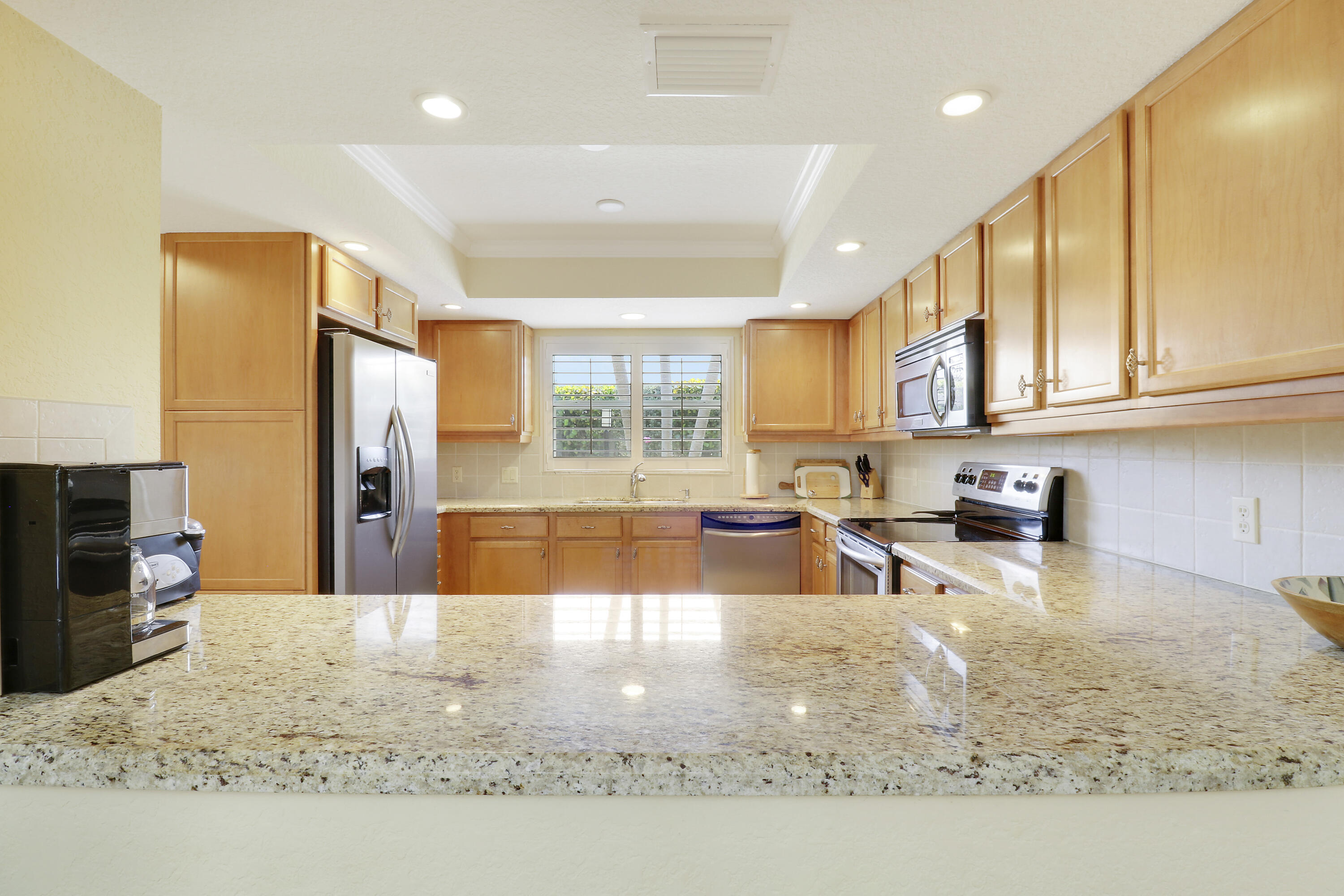 4161 U.S. Highway 1, Unit C2 Jupiter, FL 33477 - Photo 17 of 57 a kitchen with stainless steel appliances granite countertop a sink refrigerator and cabinets