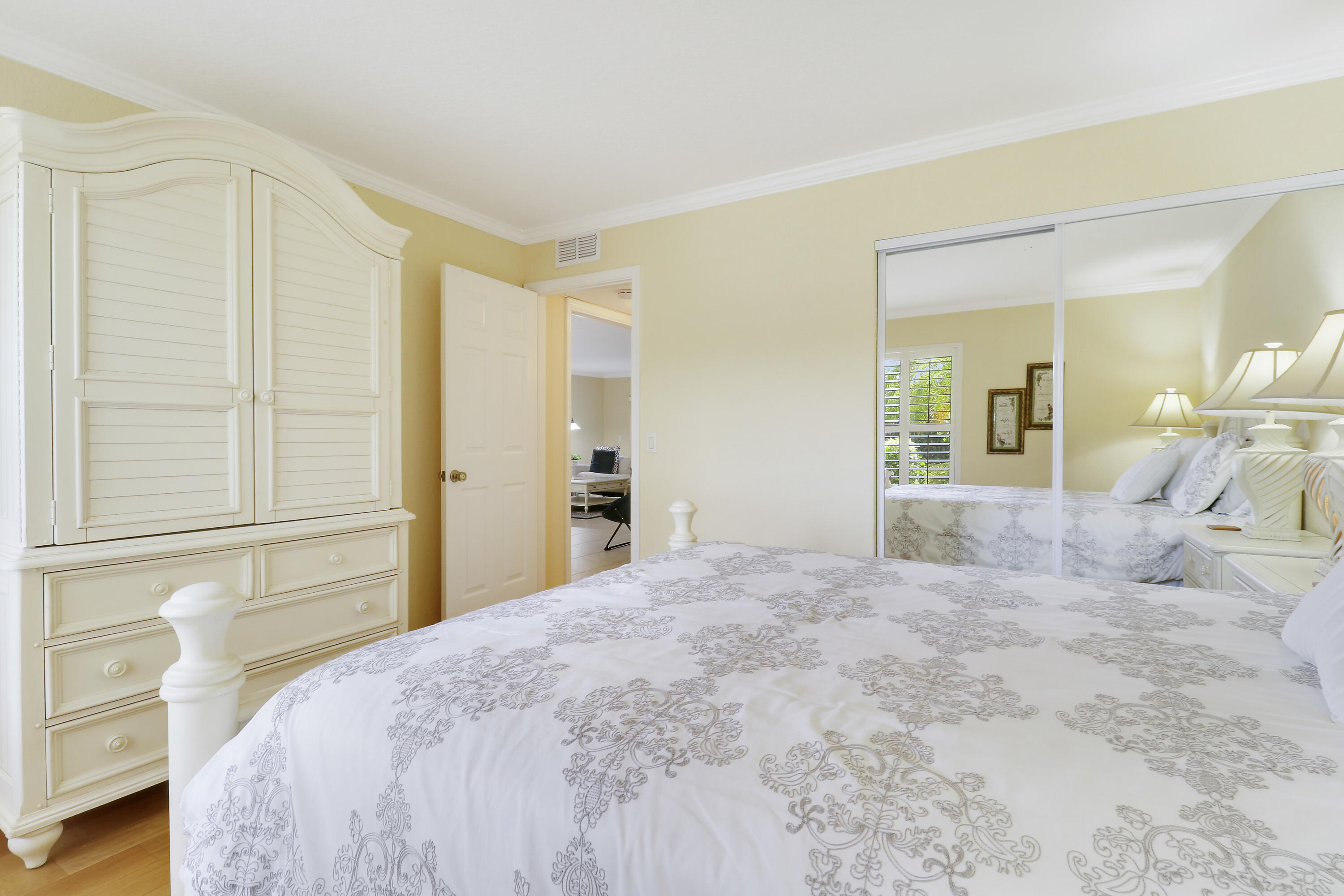 4161 U.S. Highway 1, Unit C2 Jupiter, FL 33477 - Photo 31 of 57 a bedroom with a large bed and a vanity