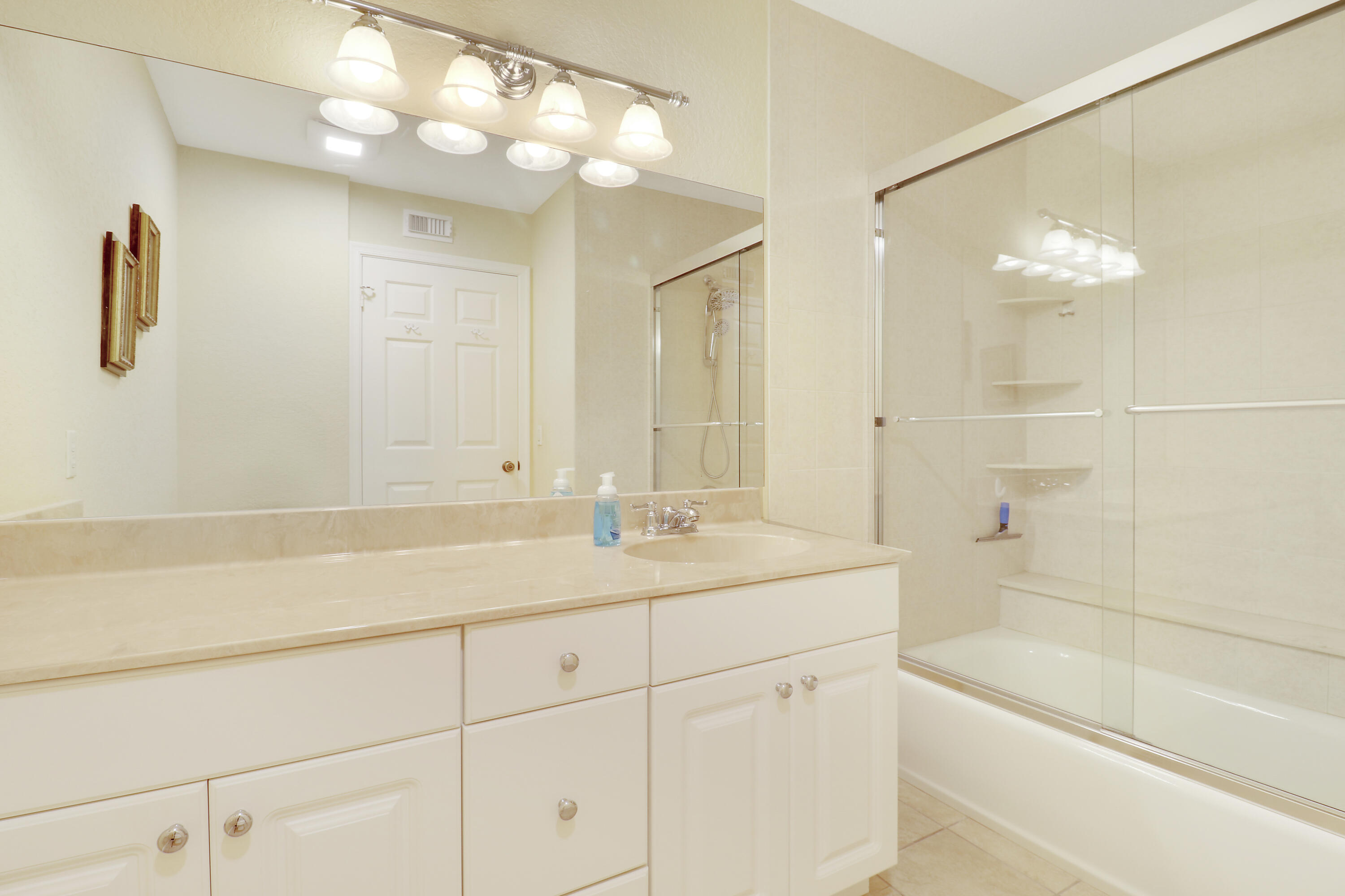 4161 U.S. Highway 1, Unit C2 Jupiter, FL 33477 - Photo 35 of 57 a bathroom with a sink double vanity granite tub shower and a mirror