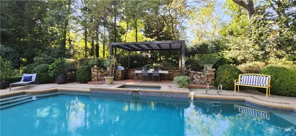 a view of swimming pool with lawn chairs and couches