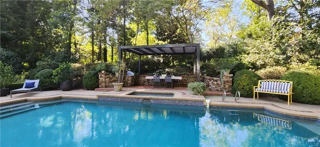 a view of swimming pool with lawn chairs and couches