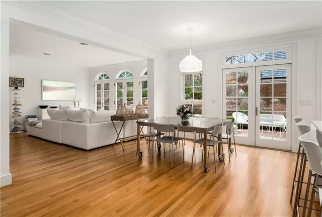 a living room with furniture and a dining table with wooden floor