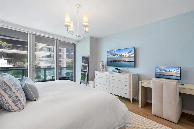 a bedroom with a large bed and a chandelier