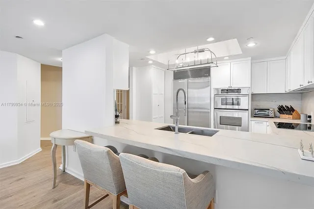 a kitchen with a sink stainless steel appliances and white cabinets