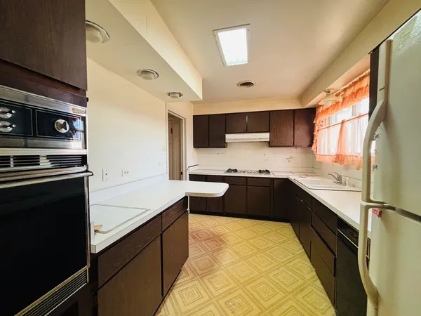 a kitchen with a sink a counter top space cabinets and stainless steel appliances