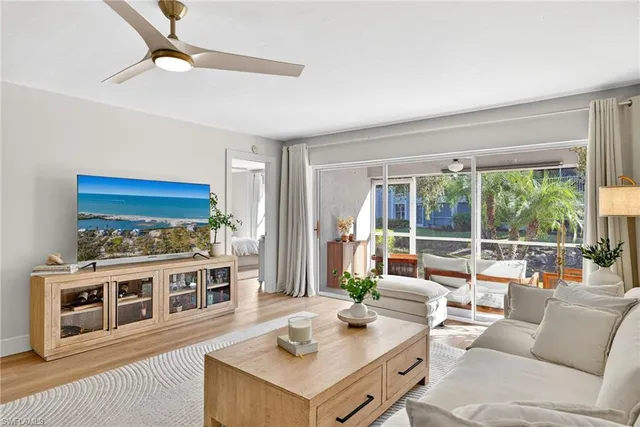 a living room with furniture a flat screen tv and a table