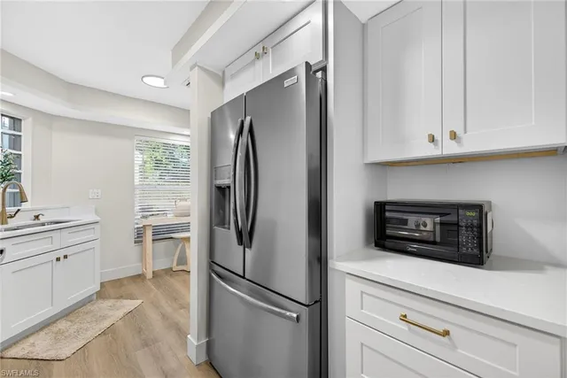 a kitchen with a refrigerator sink and cabinets