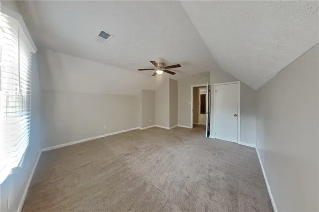 an empty room with a window and a ceiling fan