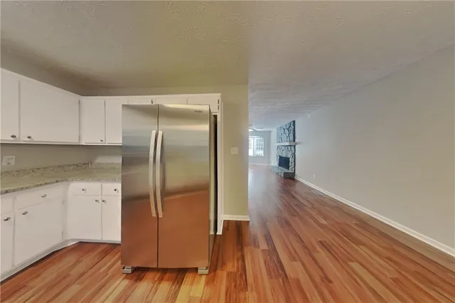 a kitchen with wooden floors and refrigerator