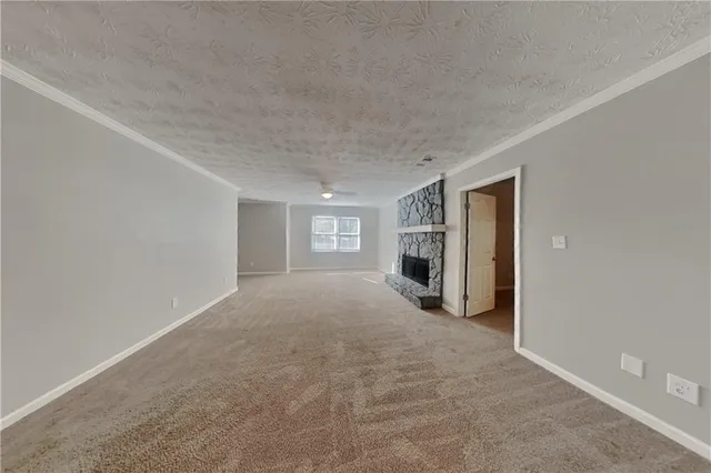 a view of an empty room with a fireplace and a window
