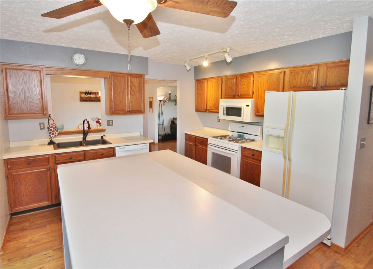 518 Pin Oak Road Rockton, IL 61072 - Photo 12 of 25 a large white kitchen with wooden floor and stainless steel appliances