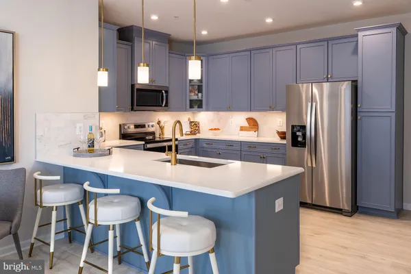 a kitchen with a table chairs refrigerator and microwave
