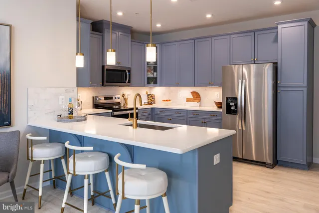 a kitchen with a table chairs refrigerator and microwave