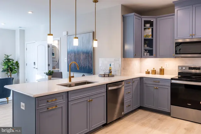 a kitchen with a sink dishwasher and a stove with wooden floor