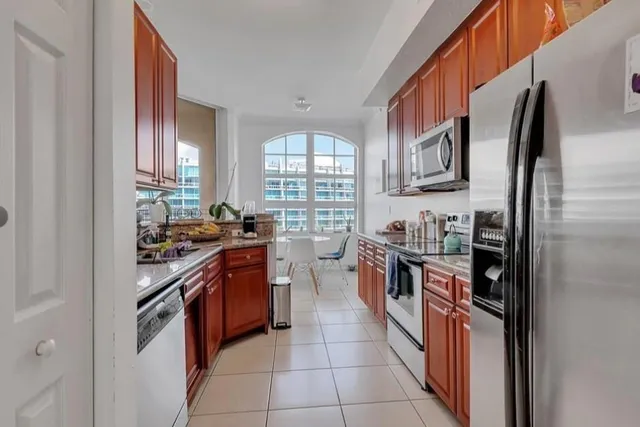 a kitchen with stainless steel appliances granite countertop a stove top oven a sink a counter space and cabinets