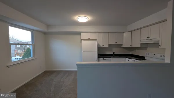 a kitchen with stainless steel appliances granite countertop a sink refrigerator and window