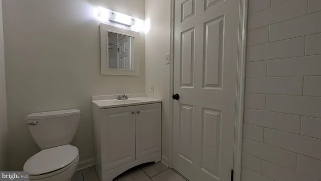 a bathroom with a toilet a sink and mirror