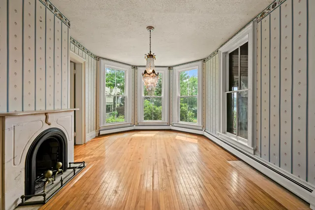 a view of empty room with wooden floor and fireplace