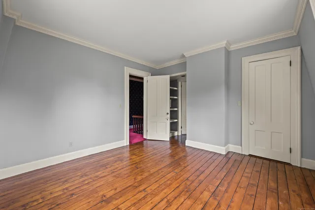 a view of an empty room with wooden floor