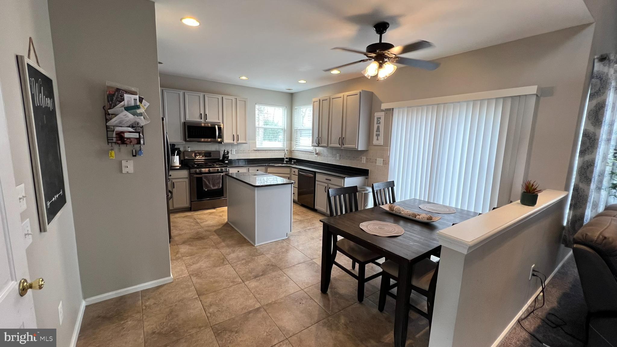 415 Stockton Loop Williamstown, NJ 08094 - Photo 11 of 41 a kitchen with sink a refrigerator and chairs