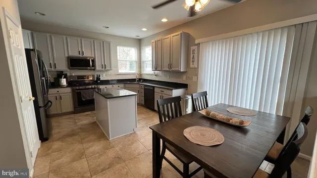 a kitchen with stainless steel appliances granite countertop a sink refrigerator stove and microwave