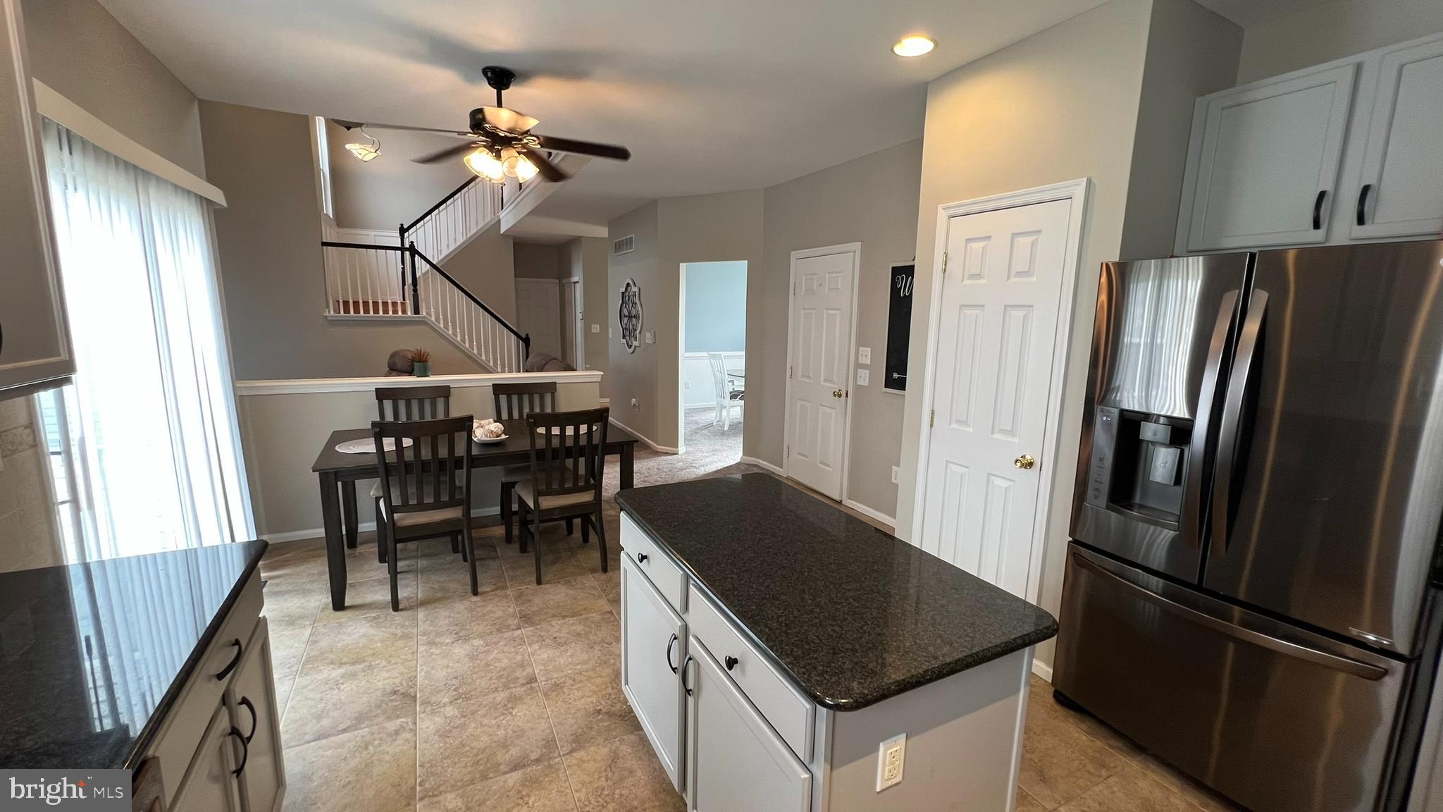415 Stockton Loop Williamstown, NJ 08094 - Photo 16 of 41 a kitchen with stainless steel appliances granite countertop a refrigerator a sink a stove and a refrigerator with wooden floor