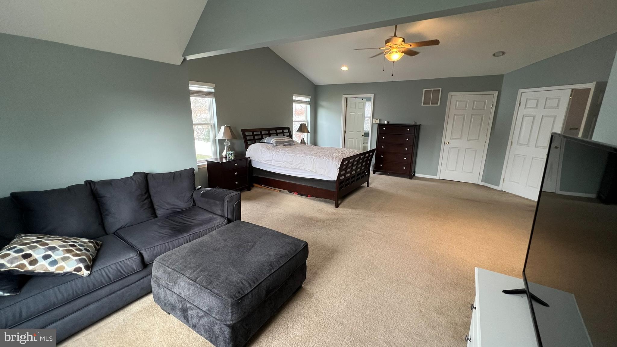 415 Stockton Loop Williamstown, NJ 08094 - Photo 28 of 41 a spacious bedroom with a bed a couch and a flat tv screen on the dresser
