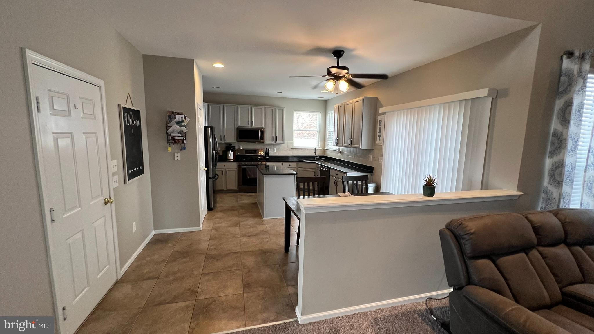 415 Stockton Loop Williamstown, NJ 08094 - Photo 9 of 41 a living room with stainless steel appliances kitchen island granite countertop furniture and a window