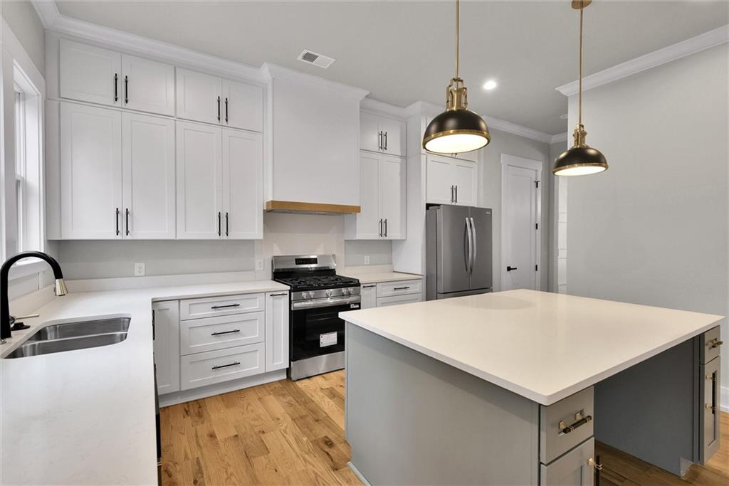 3369 Dodson Drive Connector East Point, GA 30344 - Photo 13 of 43 a kitchen with stainless steel appliances a stove a sink a refrigerator and white cabinets