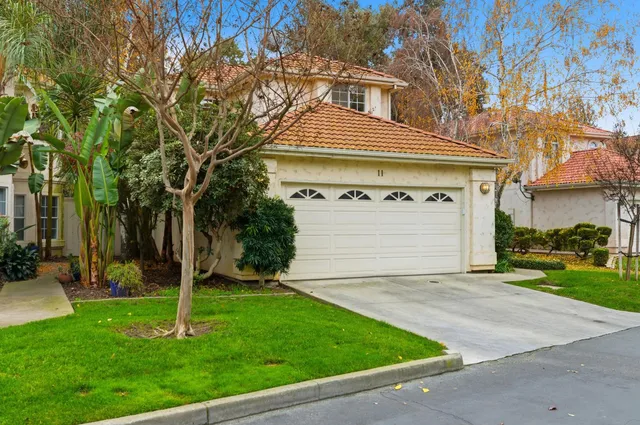a front view of a house with a yard and trees