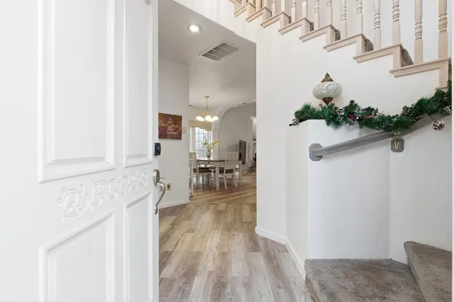 a hallway with a view of living room with wooden floor