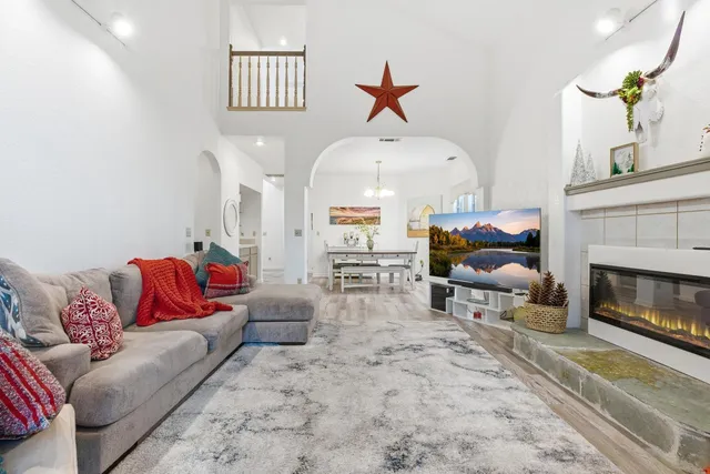 a living room with furniture a fireplace and a chandelier
