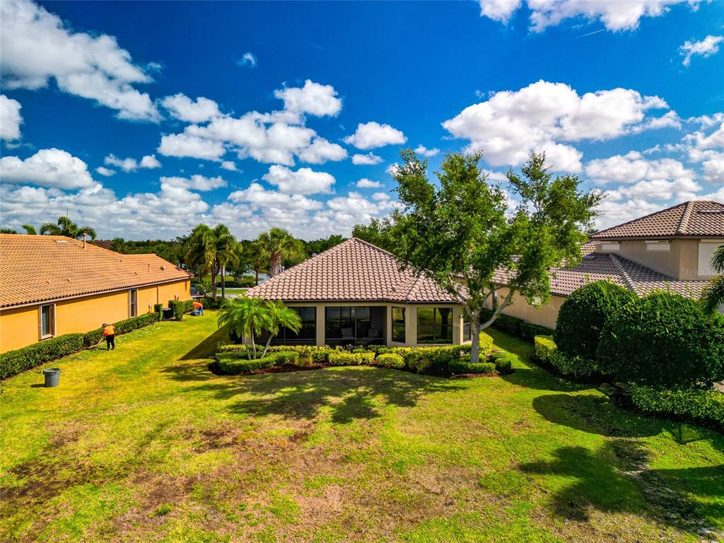 12848 Del Corso Loop Lakewood Ranch, FL 34211 - Photo 63 of 70 a view of a house with swimming pool lawn chairs and a yard