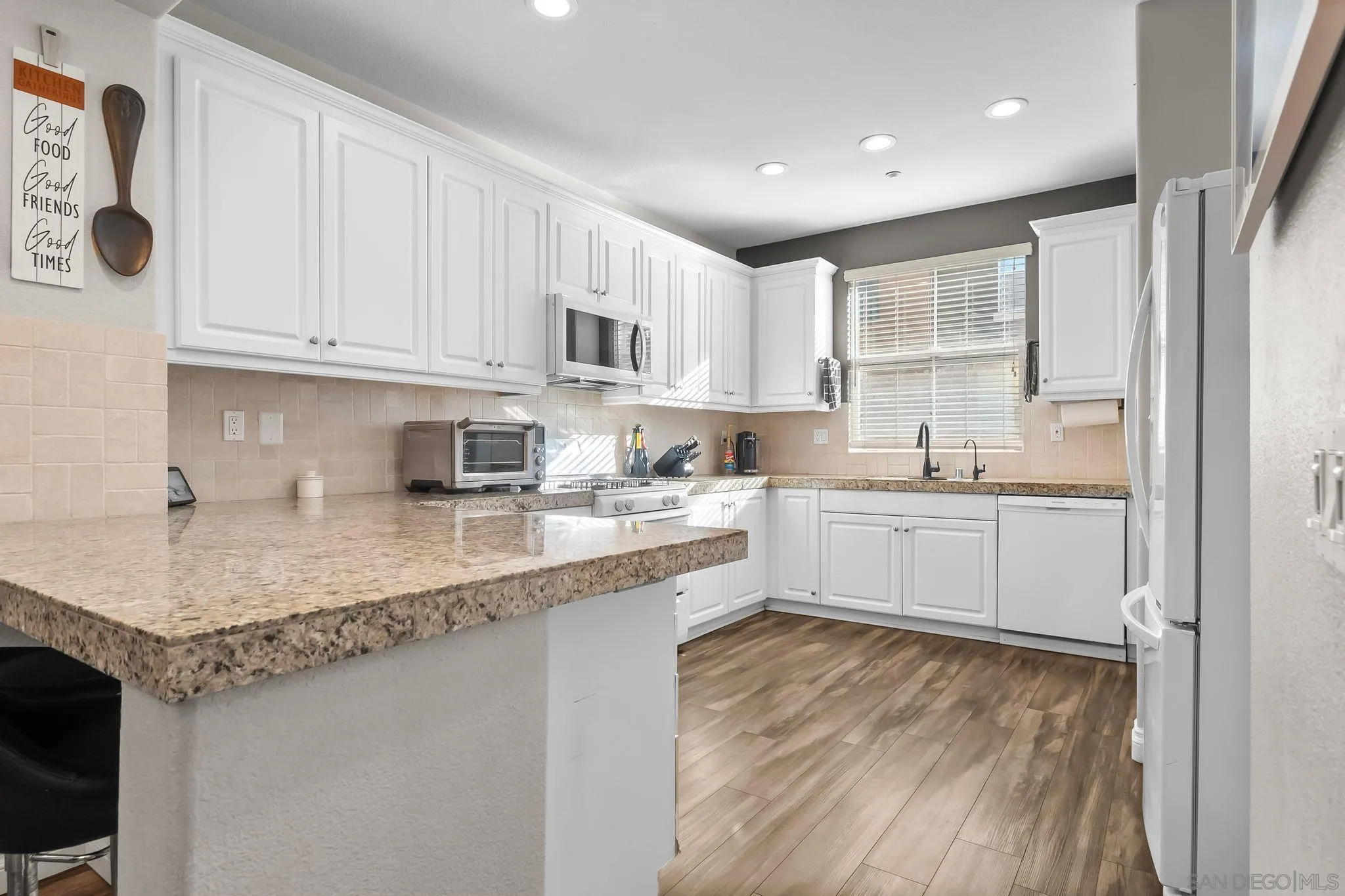10240 Daybreak Lane, Unit 2 Santee, CA 92071 - Photo 14 of 48 a kitchen with stainless steel appliances granite countertop a sink stove and white cabinets with wooden floor