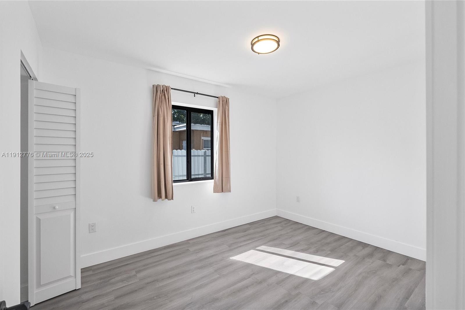 11730 Northwest 3rd Avenue Miami, FL 33168 - Photo 14 of 22 an empty room with wooden floor and windows