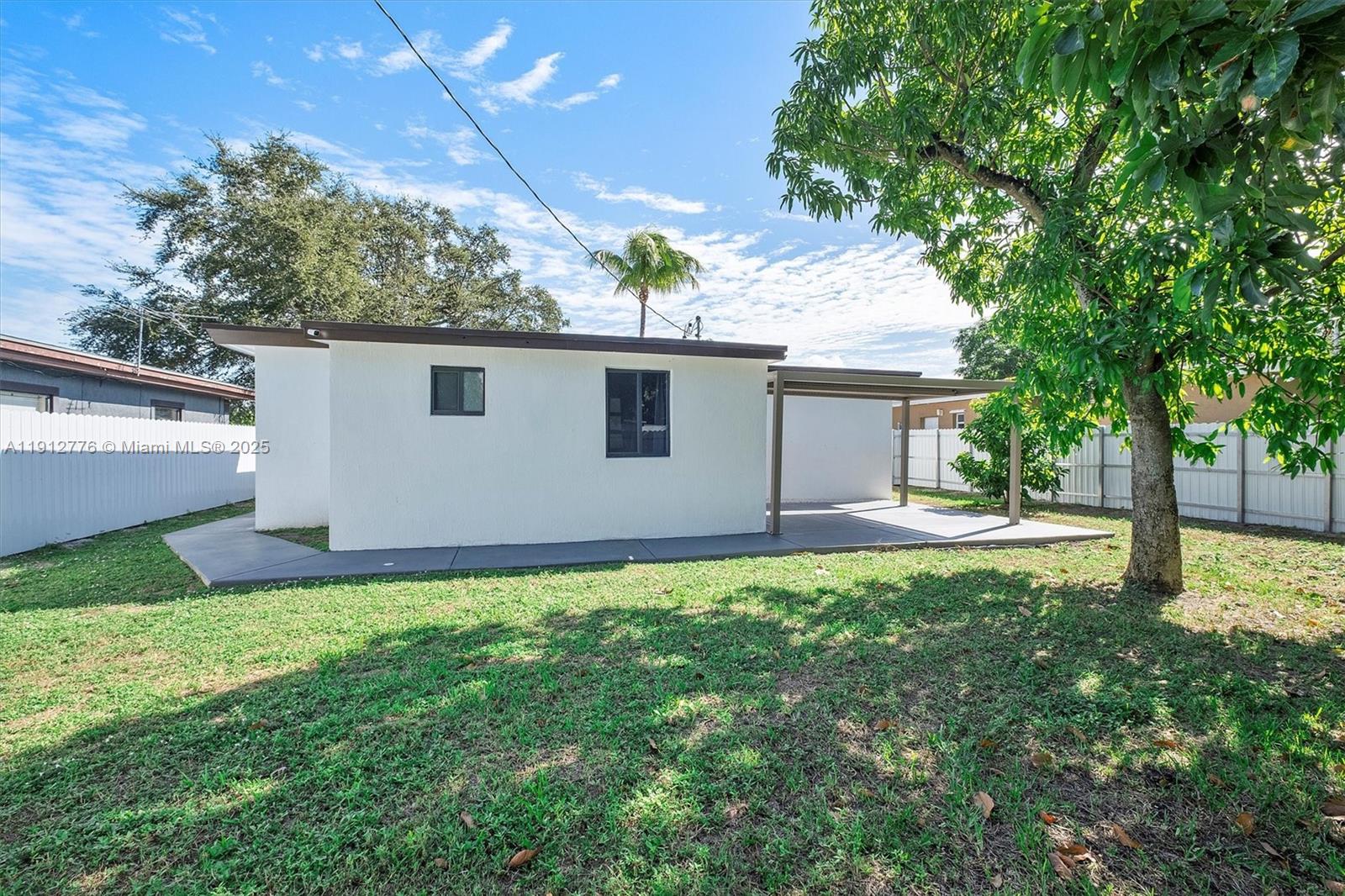 11730 Northwest 3rd Avenue Miami, FL 33168 - Photo 21 of 22 a backyard of a house with plants and large tree