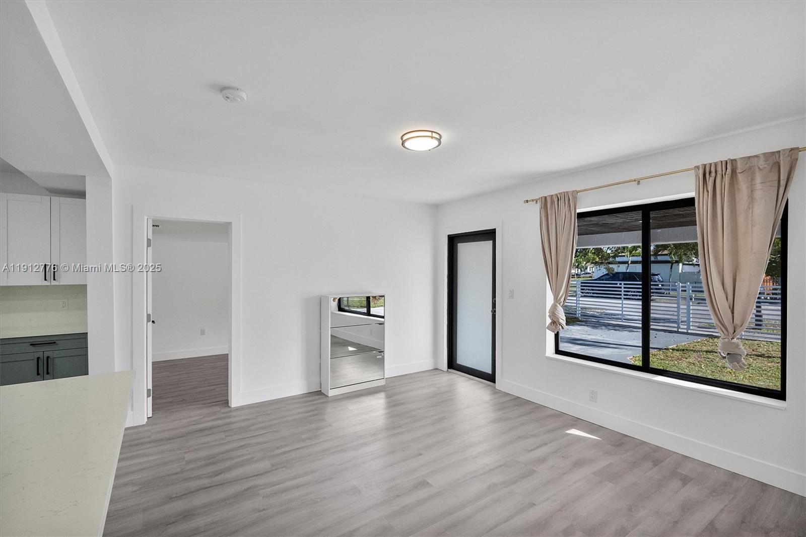 11730 Northwest 3rd Avenue Miami, FL 33168 - Photo 3 of 22 a view of a room with wooden floor and window