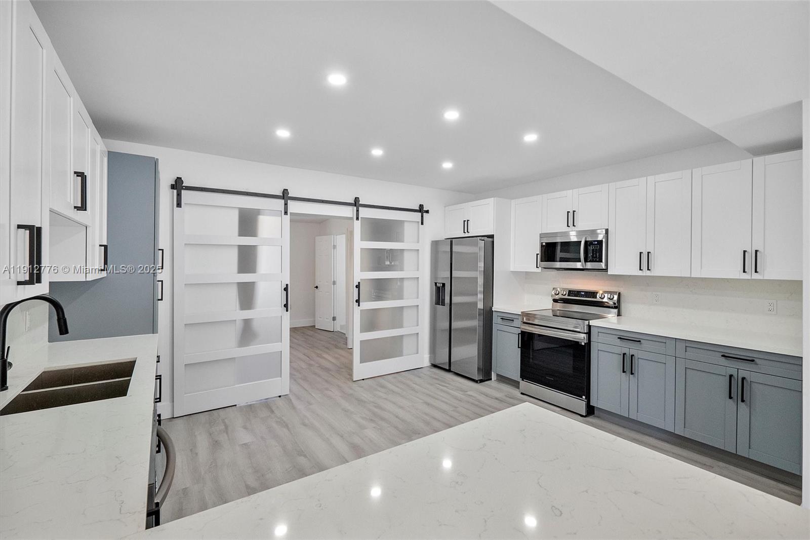11730 Northwest 3rd Avenue Miami, FL 33168 - Photo 4 of 22 a kitchen with stainless steel appliances a stove a sink and a refrigerator