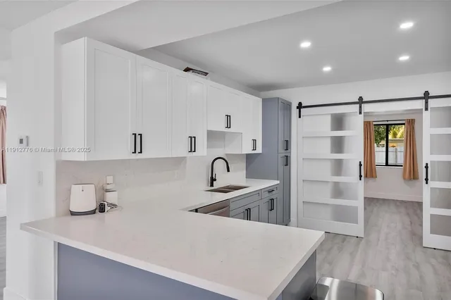 a kitchen with granite countertop a refrigerator and a sink