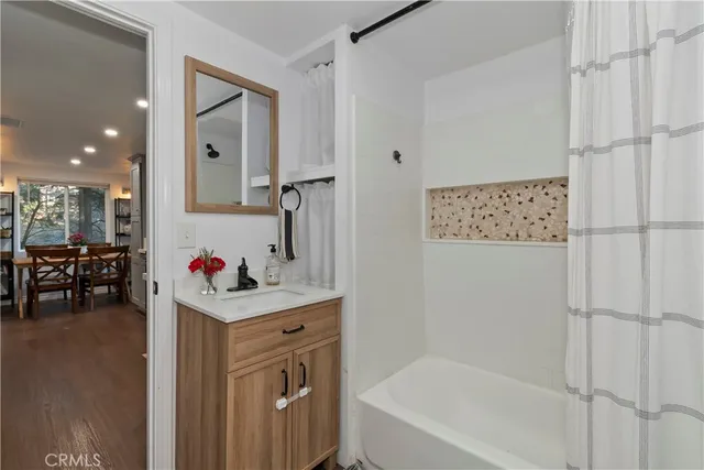 a bathroom with a bathtub sink and mirror