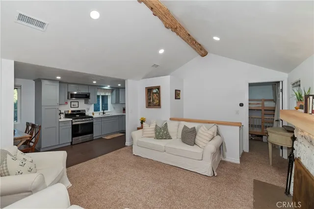a living room with furniture and view of kitchen