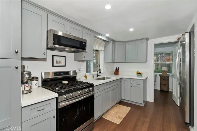 a kitchen with stainless steel appliances granite countertop a stove a sink and a refrigerator
