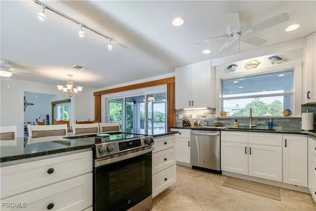a kitchen with granite countertop a sink and white cabinets
